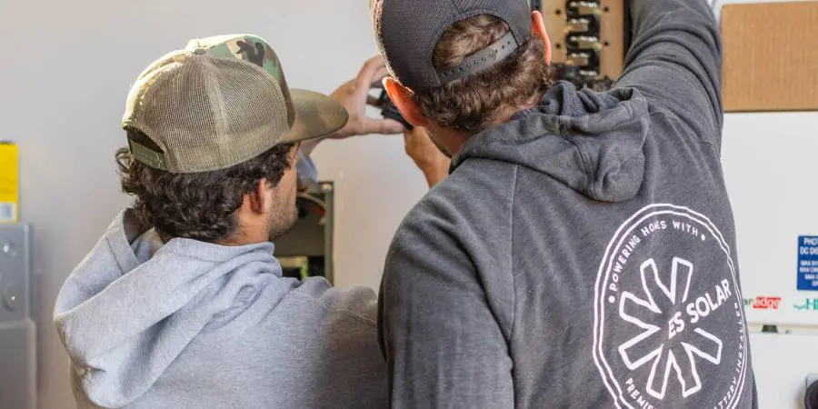 Two men installing solar equipment together.