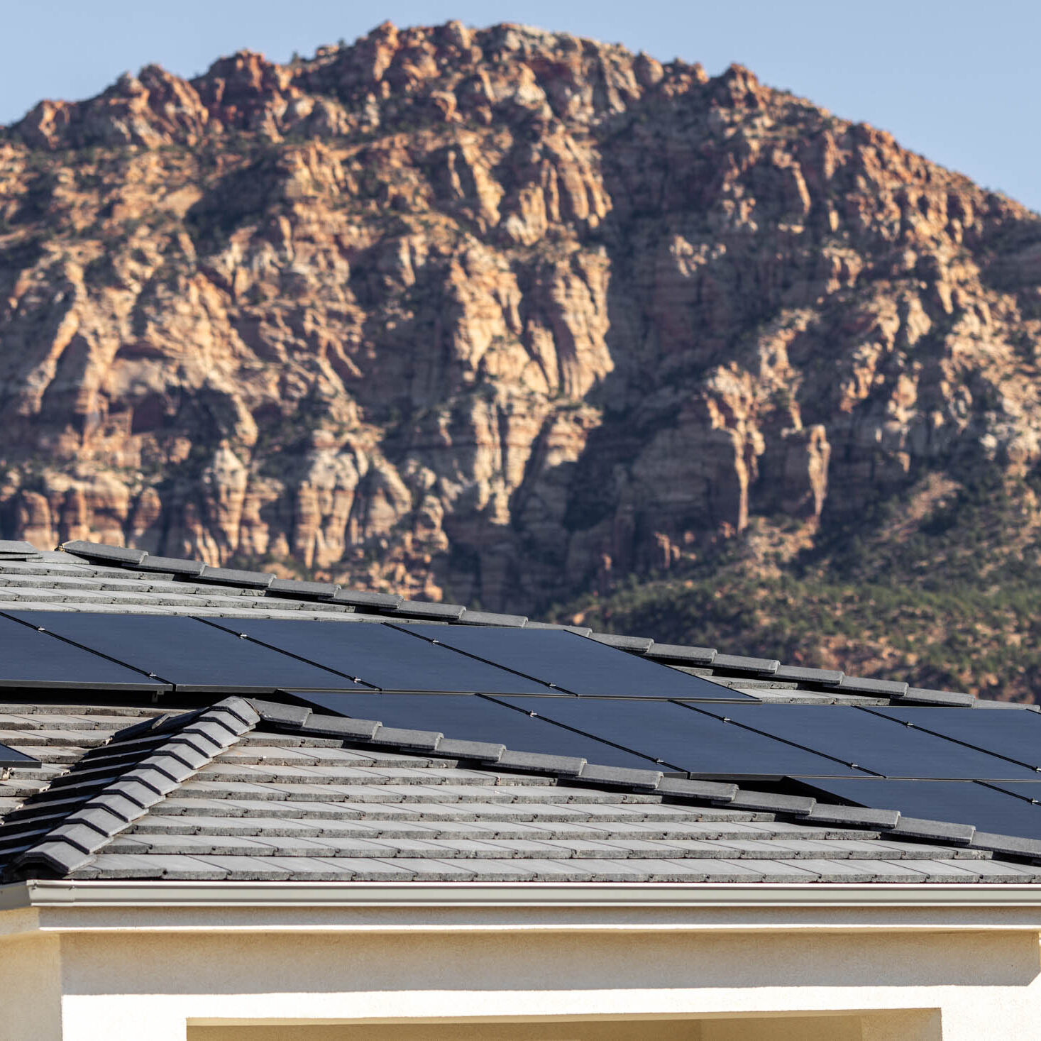 Rooftop solar panels with mountain backdrop.