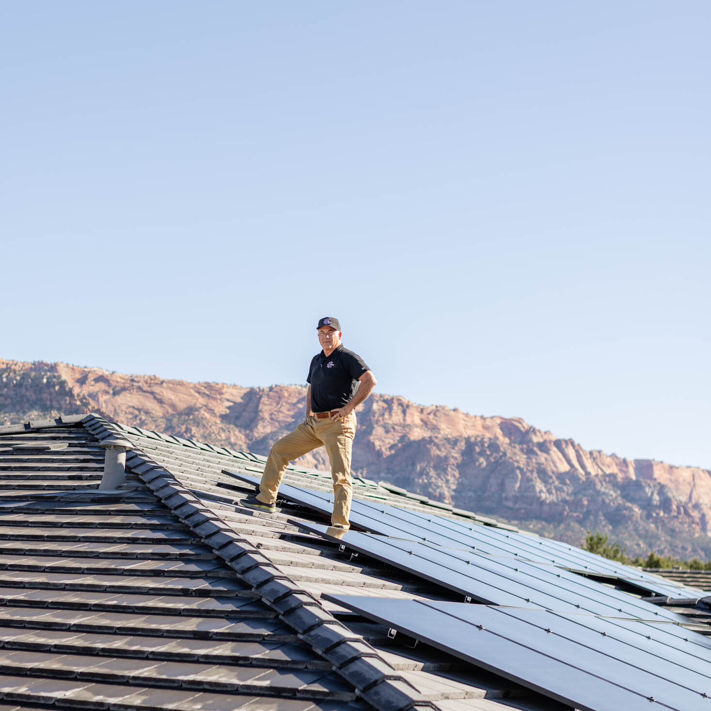 Person standing on roof with solar panels.